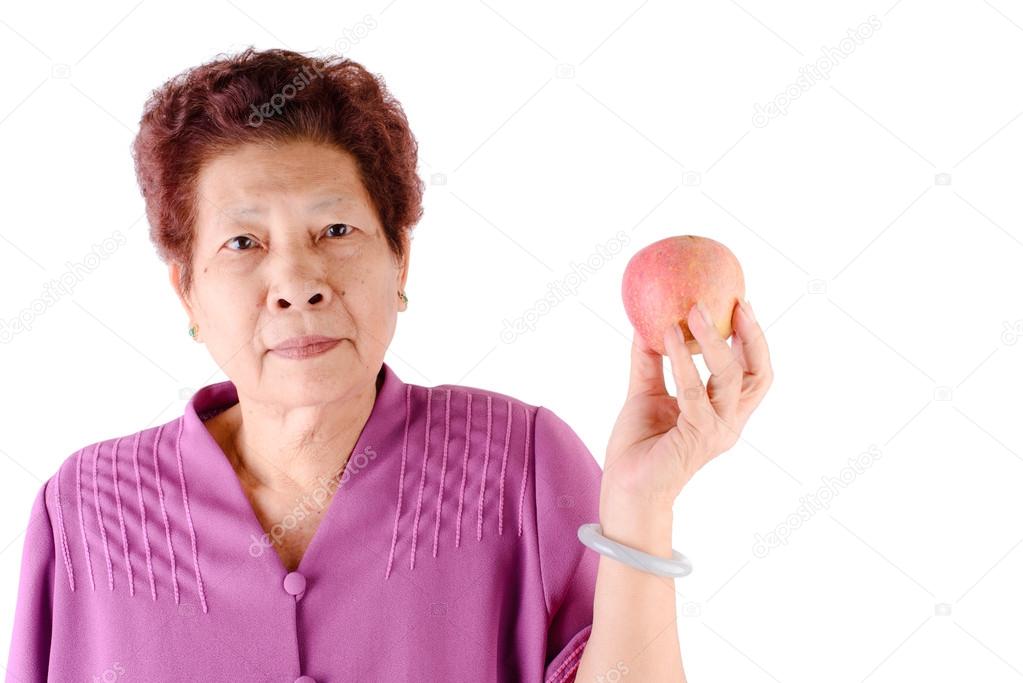 Healthy lifestyle concept. Asian senior woman eating an apple ov