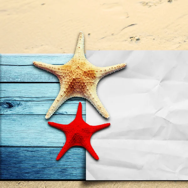 Star vis en papier op houten vloer en zand — Stockfoto