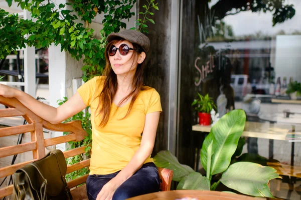 Schöne asiatische Frau trägt Sonnenbrille und Hut entspannend bei cof — Stockfoto