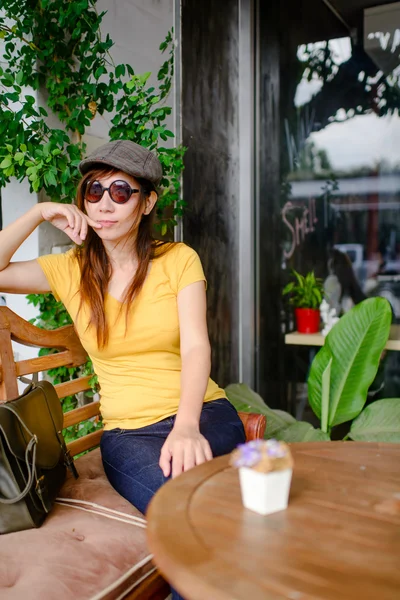 Mulher asiática bonita usando óculos de sol e chapéu relaxante no cof — Fotografia de Stock
