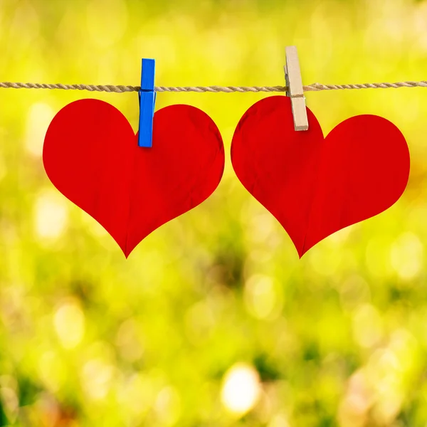 Red heart shape on note paper attach to rope with clothes pins o — Stock Photo, Image