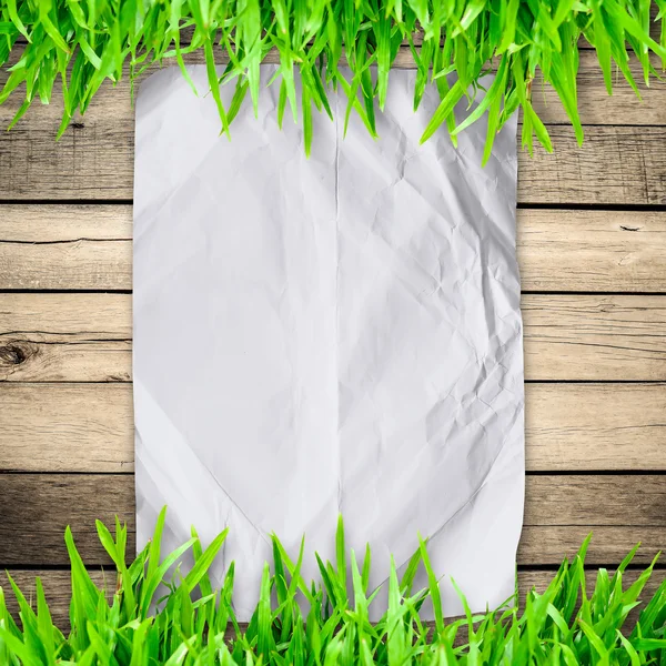 Crumpled paper on  Green grass with wooden board and copyspace f — Stock Photo, Image