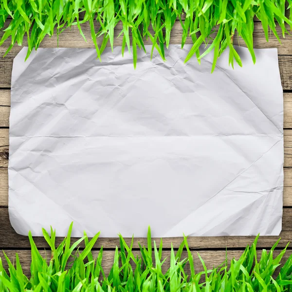 Verfrommeld papier op groen gras met houten bord en copyspace f — Stockfoto