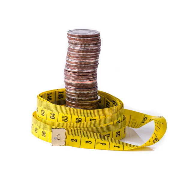 Pila di monete con metro a nastro isolata su bianco — Foto Stock