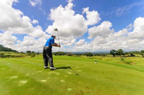 Golfista jego bieg wahadłowy i uderzyć piłeczkę z tee do f — Zdjęcie stockowe