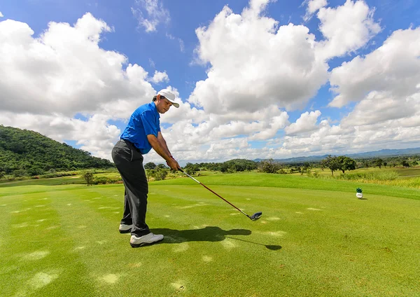 Golfista jego bieg wahadłowy i uderzyć piłeczkę z tee do f — Zdjęcie stockowe