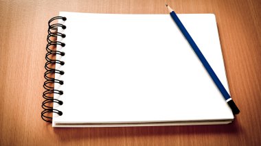 Otwórz pusty notebooka z niebieskim ołówkiem na tle drewna