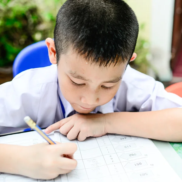 Asiatisches Kind macht Hausarbeit im Klassenzimmer — Stockfoto