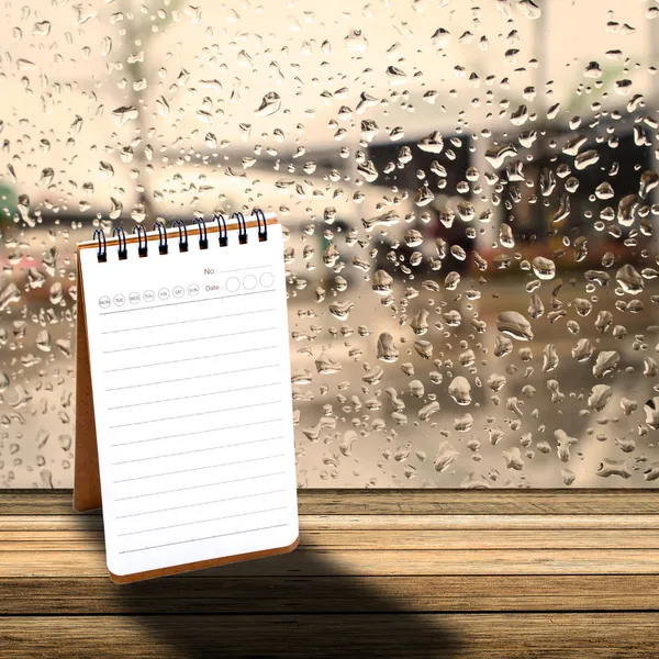 Cuaderno con fondo de ventana de día lluvioso — Foto de Stock