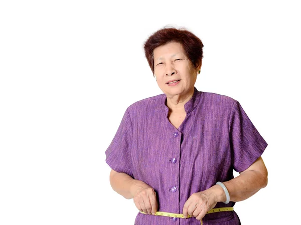 Äldre kvinna mäta midjan av centimeter — Stockfoto