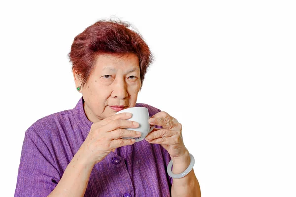 Old woman with a cup of coffee or tea — Stock Photo, Image