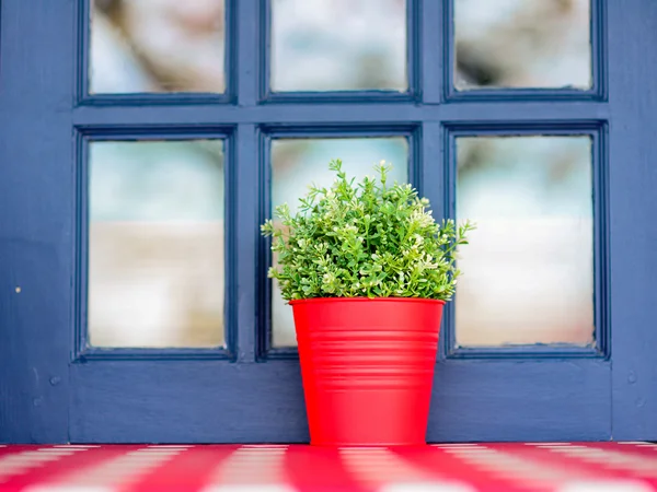 A mão de cor vermelha fez o pote de flor fora de uma janela de uma casa — Fotografia de Stock