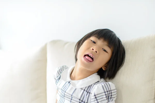 Aziatisch meisje met snoep binnen haar mond open. — Stockfoto