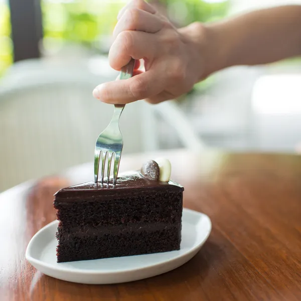 Närbild av en hand som håller en gaffel att skiva i en chocolat — Stockfoto