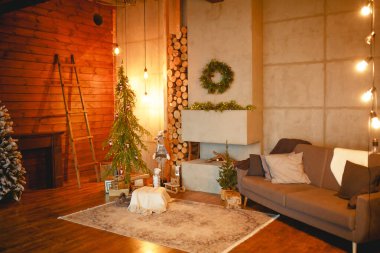 İskandinav tarzı bir Noel iç mimarisi: gri beton, ahşap dekor, parlak lambalar, gerçekçi yapay Noel ağacı. Bir kır evinde rahat bir yeni yıl