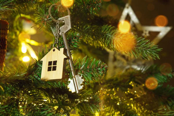 Anahtarlığı olan evin anahtarı Noel ağacında asılı. Yılbaşı hediyesi, Noel. Bina, tasarım, proje, yeni eve taşınma, ipotek, kira ve emlak satın alma. Boşluğu kopyala