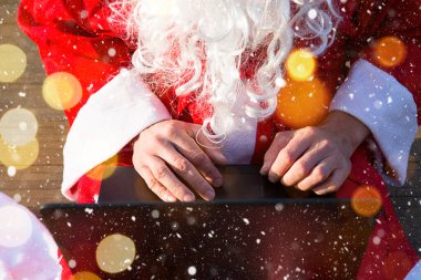 Elinde dizüstü bilgisayarı ve hediyesiyle Noel Baba. Noel ve yeni yıl hediyelerini çevrimiçi mağazadan sipariş et. Tatil için bir animatörün hizmetlerini ayırtmak.