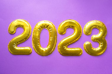 Yeni yılınız kutlu olsun. Mor arka planda, pullu, yıldızlı, parıltılı, çelenkli altın sayılar 2023. Selamlar, kartpostal. Takvim, kapak. 
