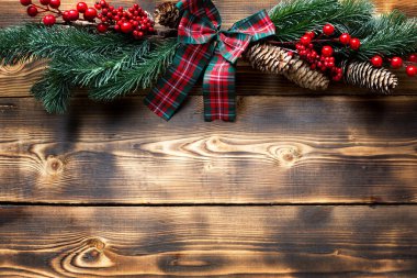 Ahşap bir arka planda Noel dekoru. Yeni yıl, tatil havası, yeşil ladin dalları, dekorasyon: yıldızlar, hediye kutusu, Noel ağacı, kar taneleri, koniler. telif alanı, çevre dostu arka plan, düz yatış
