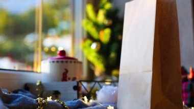 Elle alınır ve Noel dekorunda yemek servisi paketini masaya koyar. Çevre dostu geri dönüşümlü ambalaj. Tatil yemekleri, tatlı, kurabiye ve ev yapımı tatlılar. maket yap