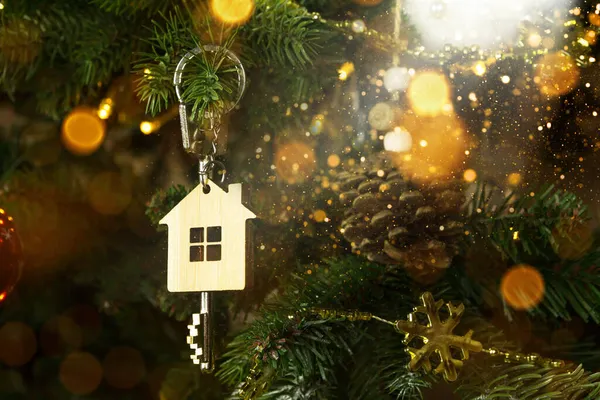 Anahtarlığı olan evin anahtarı Noel ağacında asılı. Yılbaşı hediyesi, Noel. Bina, tasarım, proje, yeni eve taşınma, ipotek, kira ve emlak satın alma. Boşluğu kopyala
