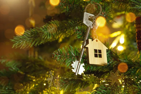 Anahtarlığı olan evin anahtarı Noel ağacında asılı. Yılbaşı hediyesi, Noel. Bina, tasarım, proje, yeni eve taşınma, ipotek, kira ve emlak satın alma. Boşluğu kopyala