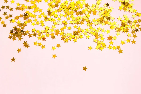 星星形状的金色亮片在粉色背景上闪烁着光芒 背景为假日 派对装饰 圣诞节和新年 生日和周年纪念日提供了版权空间 梯度和质感 — 图库照片