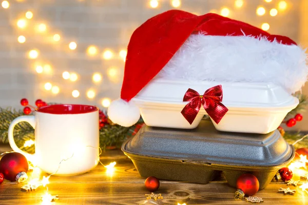 Yemek dağıtım konteynırlarının Noel dekoru. Yılbaşı gecesi terfisi. Sipariş hazır, tek kullanımlık plastik kutu masanın üzerinde. Bayramlarda yemek şirketinde çalışıyorum. Uzayı kopyala, taklit et
