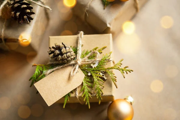 Pack a gift for Christmas and new year in eco-friendly materials: kraft paper, live fir branches, cones, twine. Tags with mock up, natural decor, hand made, DIY. Festive mood. Flatly, background