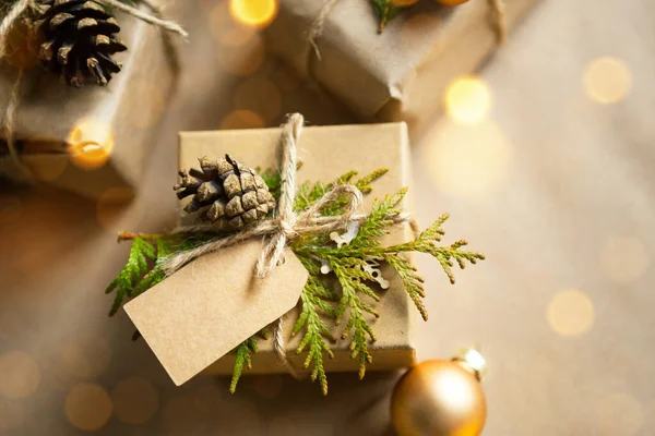 Noel ve yeni yıl hediyelerini çevre dostu malzemelerle paketleyin: kraft kağıdı, köknar dalları, koniler, sicim. Sahte etiketler, doğal dekor, el yapımı, DIY. Şenlik havası. Düz, arka plan