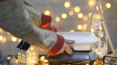 Elle alınır ve tek kullanımlık plastik kutudan sipariş verilir. Yemek dağıtım konteynırlarının Noel dekoru. Yılbaşı gecesi promosyonu. Bayramlarda yemek servisi. Peri ışıkları, ev