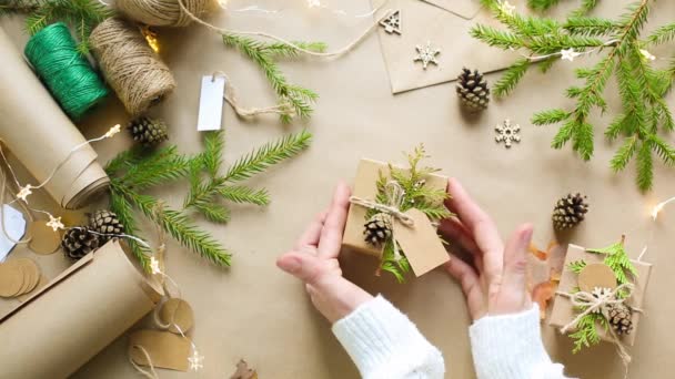 Handen Pak Een Cadeau Voor Kerstmis Nieuwjaar Milieuvriendelijke Materialen Kraftpapier — Stockvideo