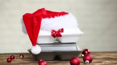 Yemek dağıtım konteynırlarının Noel dekoru. Yılbaşı gecesi terfisi. Elle alınır ve tek kullanımlık plastik kutudan sipariş verilir. Bayramlarda yemek şirketinde çalışıyorum. Noel Baba şapkası, kırmızı top