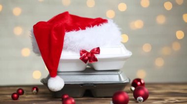 Yemek dağıtım konteynırlarının Noel dekoru. Yılbaşı gecesi terfisi. Elle alınır ve tek kullanımlık plastik kutudan sipariş verilir. Bayramlarda yemek şirketinde çalışıyorum. Noel Baba şapkası, kırmızı top