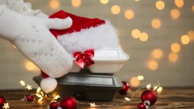 Yemek dağıtım konteynırlarının Noel dekoru. Yılbaşı gecesi terfisi. Elle alınır ve tek kullanımlık plastik kutudan sipariş verilir. Bayramlarda yemek şirketinde çalışıyorum. Noel Baba şapkası, kırmızı top