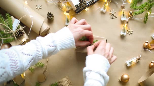 手把圣诞礼物和新年礼物打包成环保材料 牛皮纸 活枞树枝条 用弓子捆扎 带有模型的标签 天然装饰 手工制作 节日气氛 — 图库视频影像