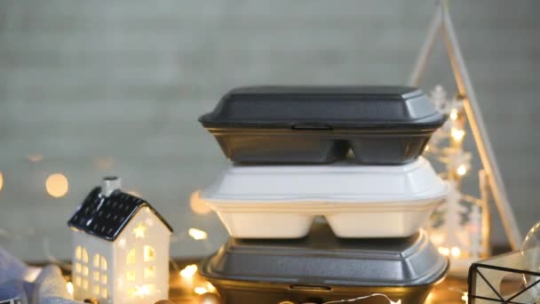 手拿起一次性塑料盒的订单放在桌上 圣诞装饰食品运送服务的容器 除夕夜促销 公共假日饮食工作 仙女灯 — 图库视频影像