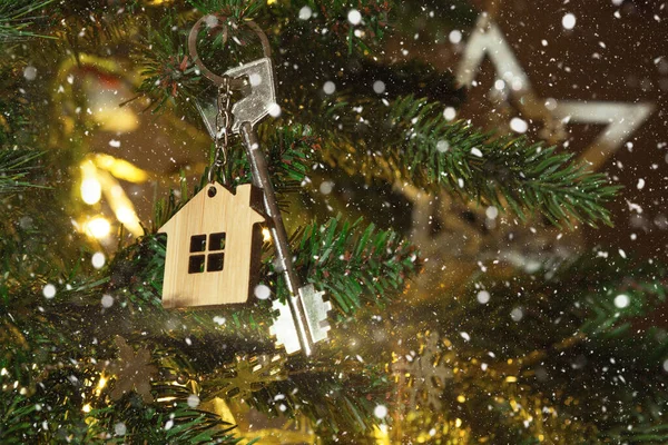 Anahtarlığı olan evin anahtarı Noel ağacında asılı. Yılbaşı hediyesi, Noel. Bina, tasarım, proje, yeni eve taşınma, ipotek, kira ve emlak satın alma. Boşluğu kopyala
