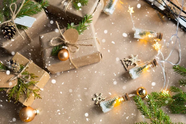Pack a gift for Christmas and new year in eco-friendly materials: kraft paper, live fir branches, cones, twine, snow. Tags with mock up, natural decor, hand made, DIY. Festive mood. Flatly, background