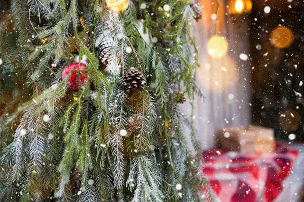 クラフト紙のクリスマスのための贈り物を持つボックスは 屋外のクリスマスツリーの近くに再生された赤いプレイにあります 新年の気分 妖精の光の街の装飾 ロイヤリティフリーのストック写真