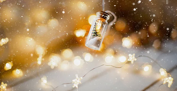 黄金のガーランドと暖かい居心地の良い雰囲気の中でクリスマスツリーと雪のクローズアップを持つ瓶の中の妖精の光 クリスマスと新年 お祝いの装飾 コピースペース クリスマスの背景 ロイヤリティフリーのストック写真