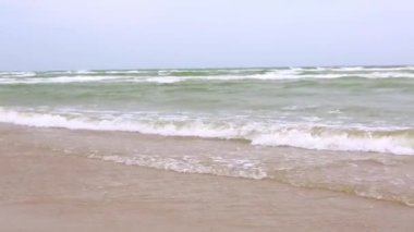 Deniz köpüklü sık dalgalar bulutlu havada