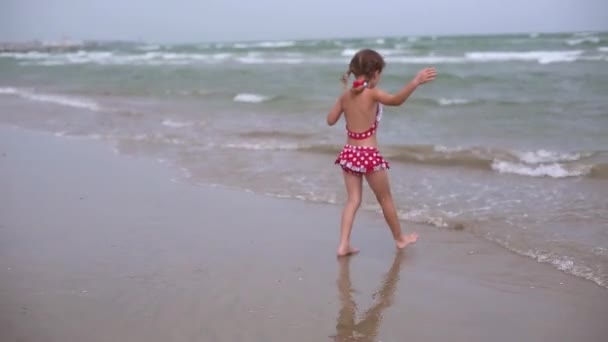 Little Girl Red Swimsuit Playing Beach Sea Wave Jumping Running — Stockvideo