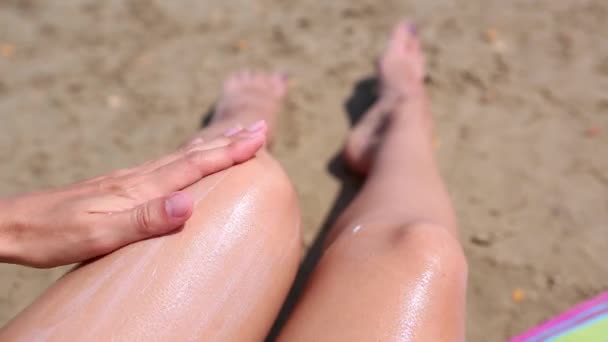海滩上的一个女人用橙色管子里的防晒霜擦拭她的脚 紫外线防护 防晒霜 海滩假日 — 图库视频影像