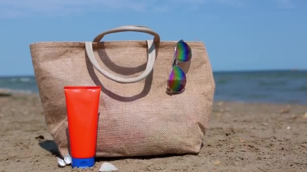 Tubo Arancione Con Crema Solare Occhiali Sole Una Borsa Spiaggia — Video Stock