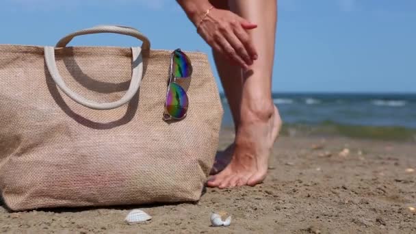 Kobieta Bierze Krem Filtrem Masuje Stopy Plaży Pomarańczowa Rurka Makietą — Wideo stockowe