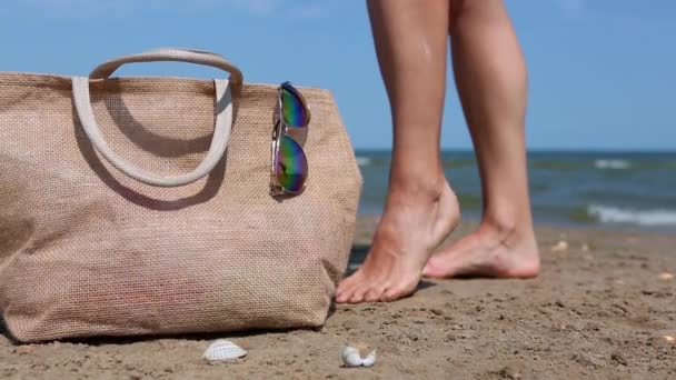 Μια Γυναίκα Παίρνει Αντηλιακό Και Τρίβει Πόδια Της Στην Παραλία — Αρχείο Βίντεο