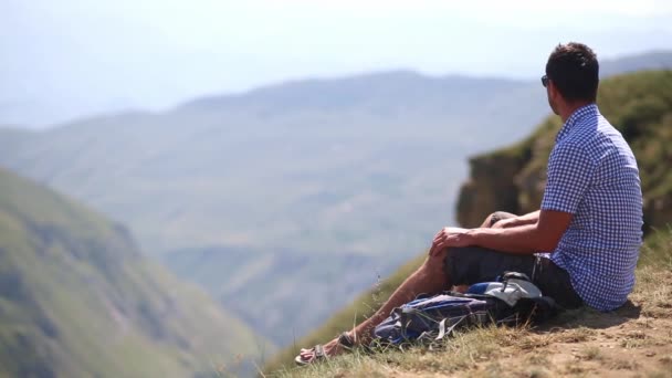 Mann Mit Rucksack Sitzt Rand Einer Klippe Den Bergen Und — Stockvideo