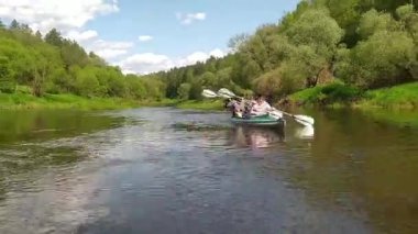 Family kayak trip. An elderly married couple with a grandson rowing a boat on the river, a water hike, a summer adventure. Tourism, active old age. Russia, Kaluga, summer 2021