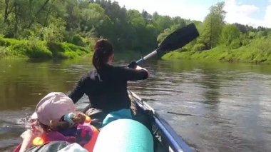 Family kayak trip. Mom and daughter rowing a boat on the river, a water hike, a summer adventure. Eco-friendly and extreme tourism, active and healthy lifestyle